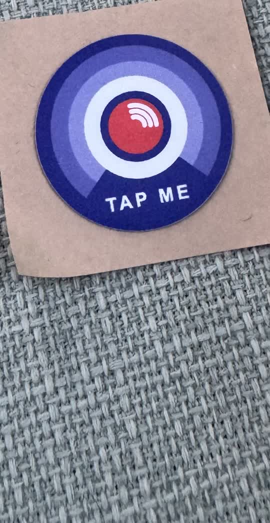 A round tapcord tag on its cardboard backing.